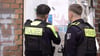 Zwei Polizisten entfernen ein Plakat, das den am Mittwoch erschossenen Deutsch-Israeli Yaron Lischinsky zeigt.