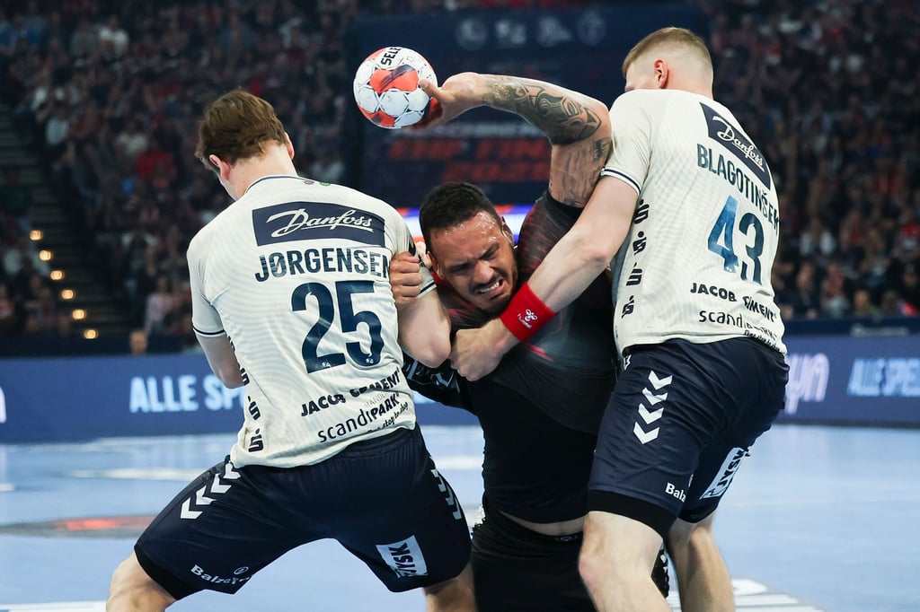 Rogerio Moraes (M) wird von den Flensburgern Lukas Jörgensen (l) und Blaz Blagotinsek am Wurf gehindert.