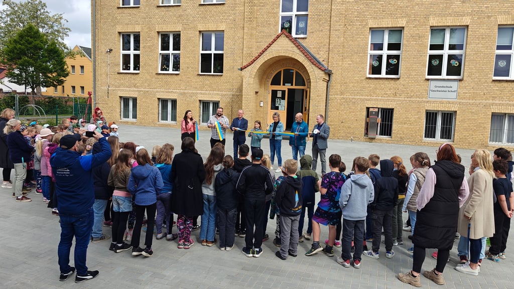 Das Band in den Stadtfarben Blau und Gelb wurde symbolisch durchschnitten. Die Schüler wurden dabei von Tjara Leisering (M.) aus der vierten Klasse vertreten.