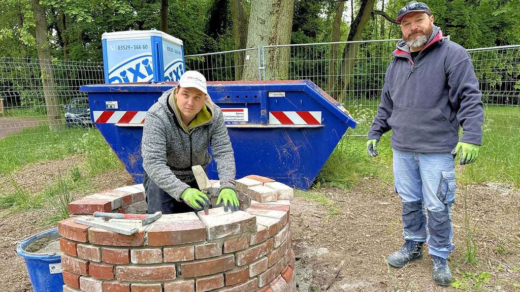 Die Maurer Enrico Ruf und Dan Proctor bauen den kleinen Turm im Schlosspark Möckern wieder auf.