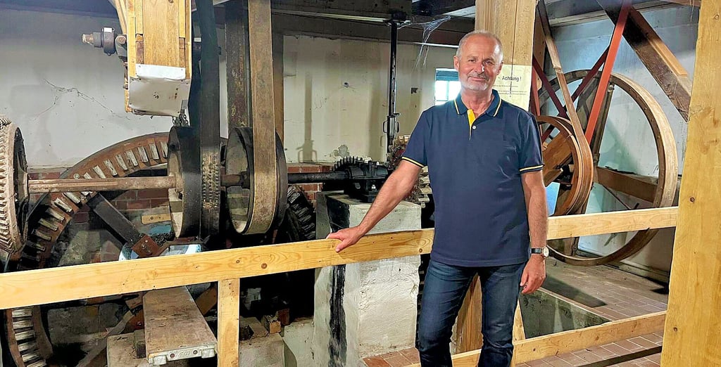 Roland Sonne zeigt, wie der mechanische Antrieb der Wassermühle funktioniert. In der Mitte wird der Balken, auf dem das Wasserrad liegen wird, eingebaut.