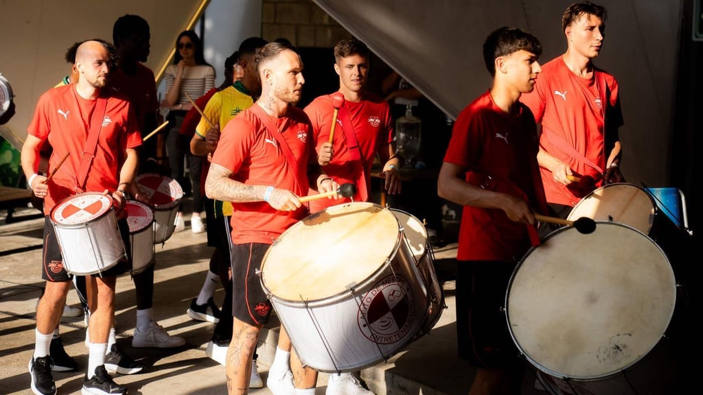 Spieler von RB Leipzig lernen das trommeln mit Samba-Instrumenten