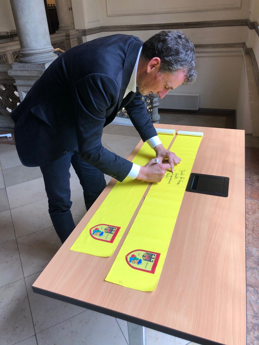Stadtratsvorsitzender Jan Riedel (CDU) trägt sich auf dem "gelben Band" ein.