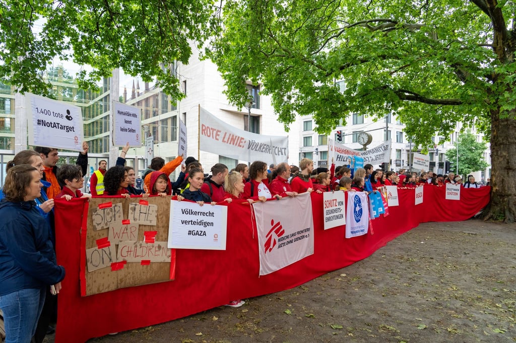 Mitarbeiter von Hilfsorganisationen demonstrieren in Berlin für mehr Hilfsgüter in Gaza.