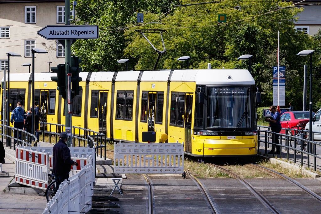 Eine Straßenbahn fährt in den gesicherten Bereich an der gesperrten Brücke an der Wuhlheide im Ortsteil Oberschöneweide.