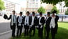 Männertruppe mit Frack, Zylinder und Spazierstock in der Magdeburger Innenstadt unterwegs.