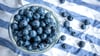 Beeren statt Chips oder Nüsschen: Heidelbeeren, auch Blaubeeren genannt, liegen auf einem Esstisch und werden gern gesnackt.