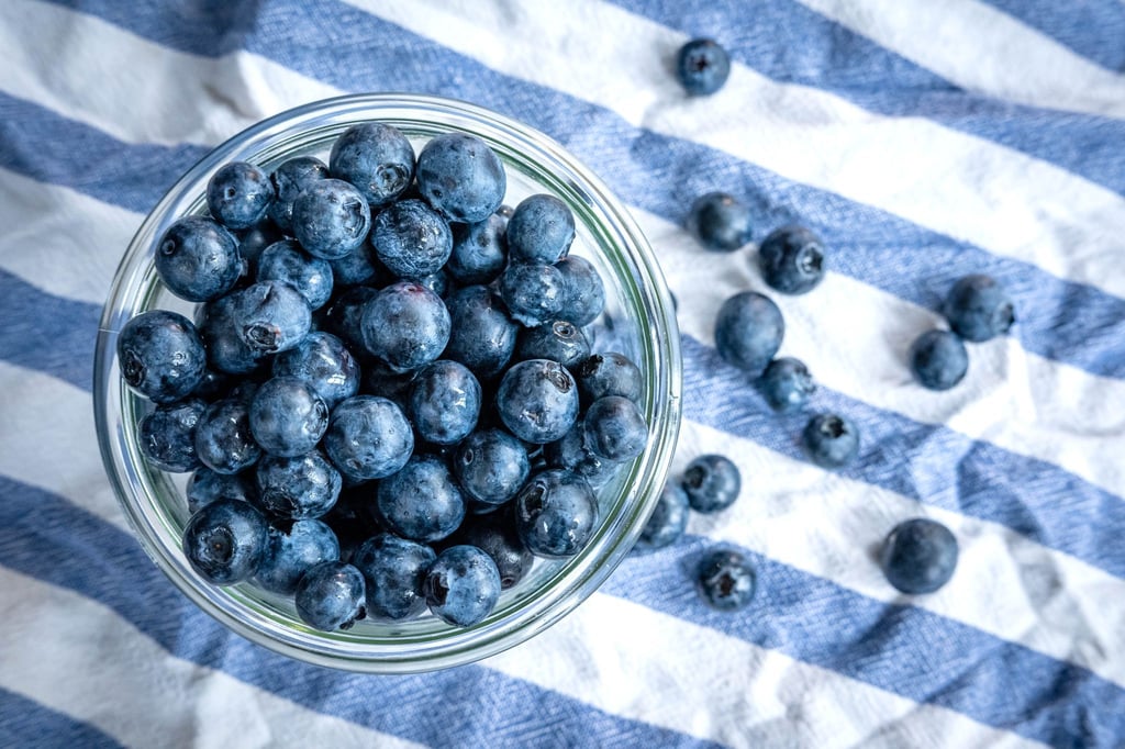 Beeren statt Chips oder Nüsschen: Heidelbeeren, auch Blaubeeren genannt, liegen auf einem Esstisch und werden gern gesnackt.