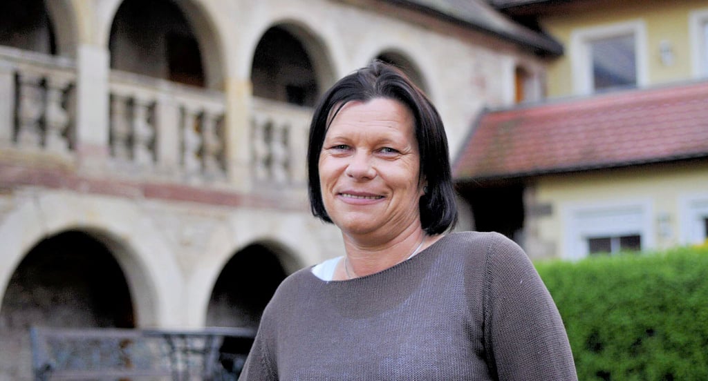 Ivonne Ihle steht in dem über prächtige historische Arkaden verfügenden Innenhof ihres Nebraer Wohngebäudes.