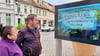 Sybille und Helmut Draber schauen sich auf dem Markt in Havelberg die neue multimediale Infotafel an.  