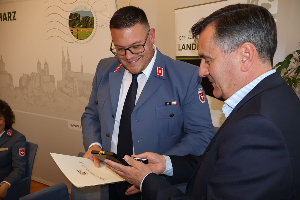 Landrat Thomas Balcerowski überreicht Tony Krutenat die Ehrennadel des Landes.