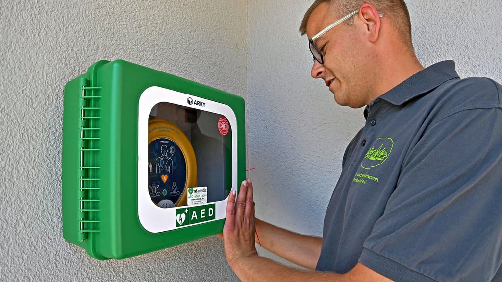 In dem Kasten befindet sich der Defibrillator. Kevin Bierstedt zeigt, wo er sich öffnen lässt.