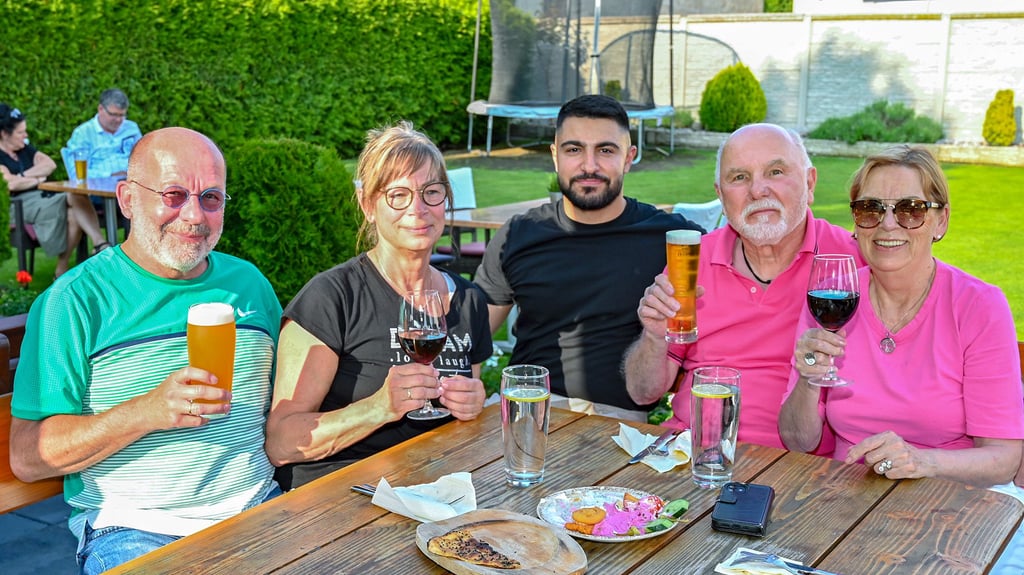 Mit Stammgästen setzt sich Hasan Kocaolgu (Mitte) auch gern einmal – wenn es die Zeit zulässt – zum Plausch an einen Tisch im Außenbereich des Musti-Bistro.