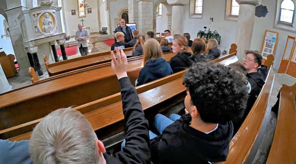 Rüdiger Kempe vom Gemeindekirchenrat zeigt den Schülern die Kirche.