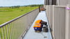 Pst... nicht stören: Tom Wiese und André Bonk  verlegen am Montag, 2. Juni 2025, Paneele (Metallroste) auf dem Bohlenweg der Eisenbahnbrücke von Losenrade nach Wittenberge. 