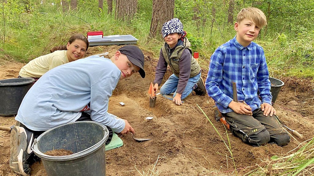 Samuel Vater (v.l.n.r.), Justin Hoffmann, Isaak Vater und Alvin Düerkop graben im Waldboden nach Spuren aus der Vergangenheit.