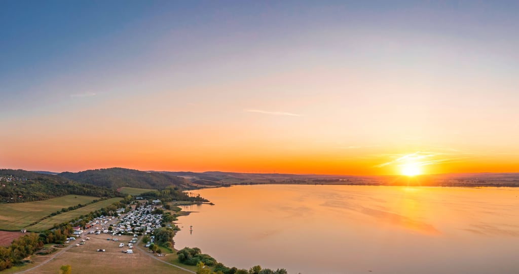 Der Stausee Kelbra aus der Vogelperspektive im Sonnenuntergang.