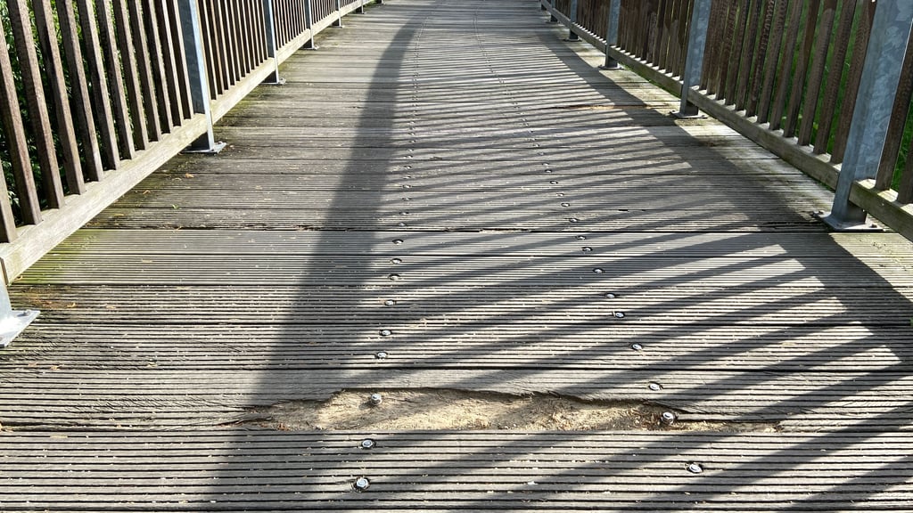 Beschädigte Holzbohle: An einer Fußgängerbrücke in Magdeburg ist eine Stelle marode.