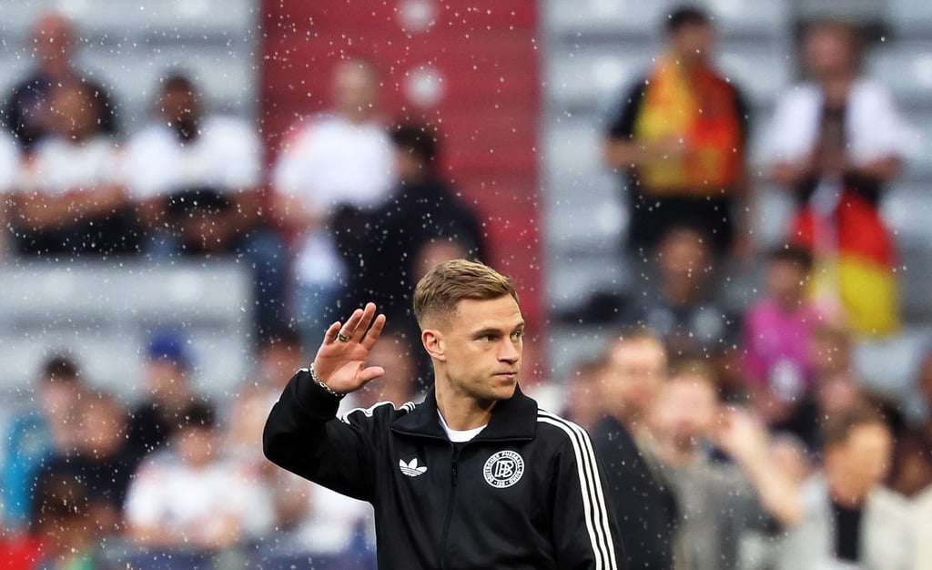 Kapitän Joshua Kimmich winkt nach der Ankunft im Münchner Stadion den Fans zu.