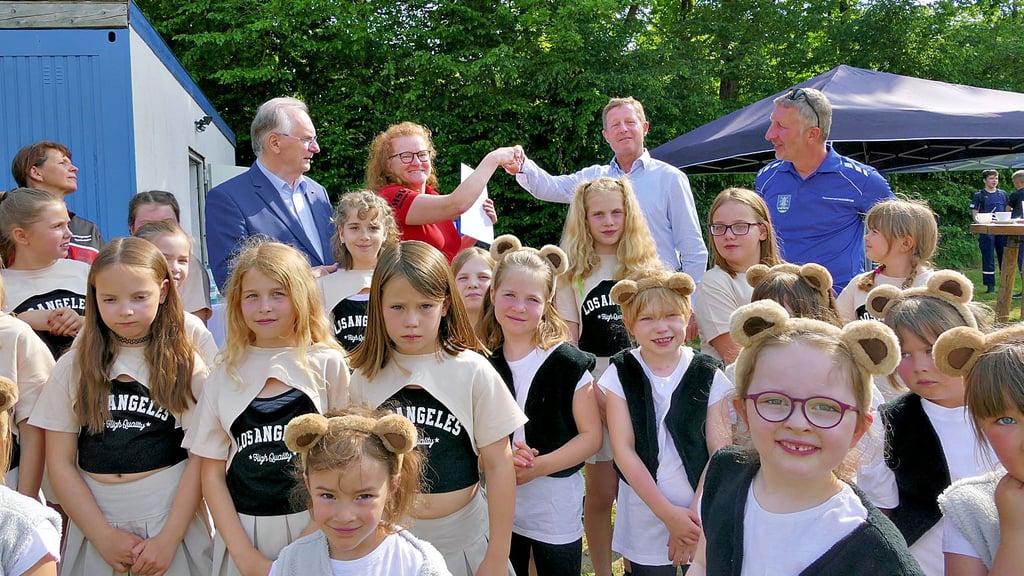 Glückwunsch! Bürgermeister Peter Müller (2. v. r. hinten) ist der erste Gratulant, nachdem Sachsen-Anhalts Ministerpräsident Reiner Haseloff (l. hinten)  einen Fördermittelbescheid über 26.700 Euro an die Vorsitzende des   Mühlangeraner SV,  Katrin Müller (Mitte hinten), überreicht hat.