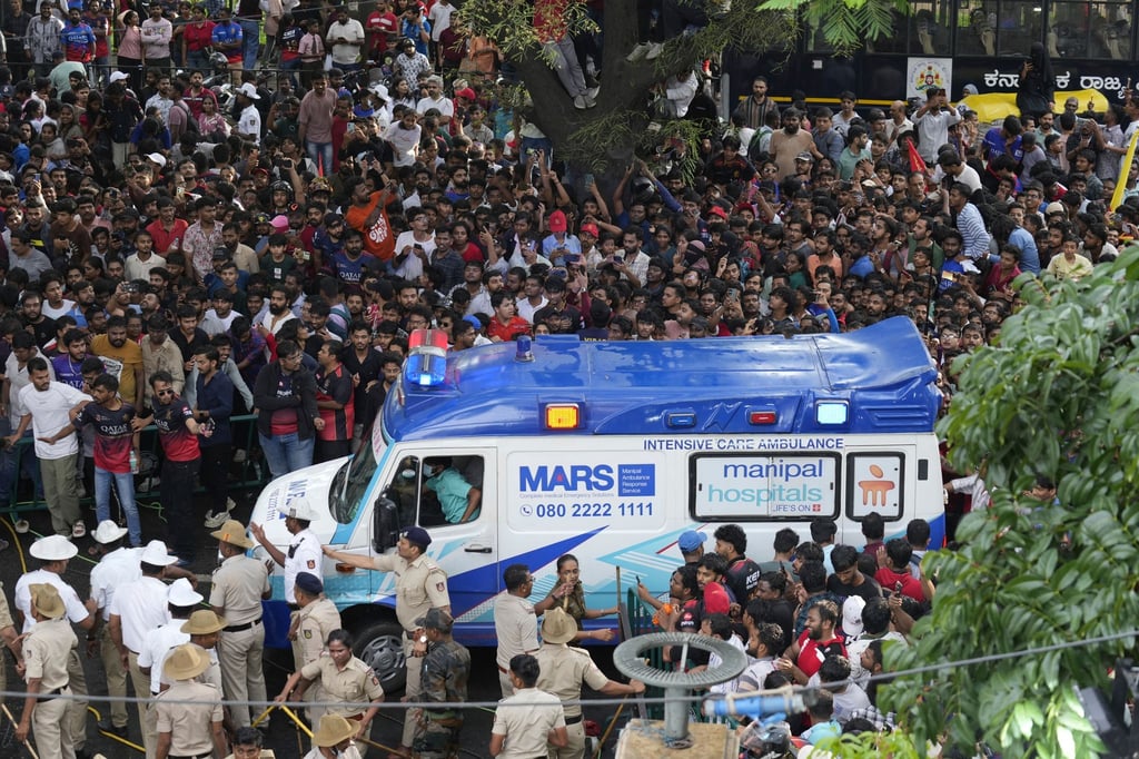 Ein Krankenwagen bahnt sich den Weg durch eine Menschenmenge am M. Chinnaswamy-Stadion in der indischen Stadt Bengaluru.