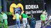 Greenpeace-Aktivisten kleben Protestplakate gegen Tierleid an die Scheiben eines Edeka-Markts.