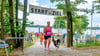 Ziel erreicht. Eine Teilnehmerin des Hundetriathlons läuft gemeinsam mit ihrem Vierbeiner über die Ziellinie am Bergwitzsee. Der sportliche Dreikampf  findet am 5. Juli dieses Jahres zum mittlerweile 16. Mal statt. 
