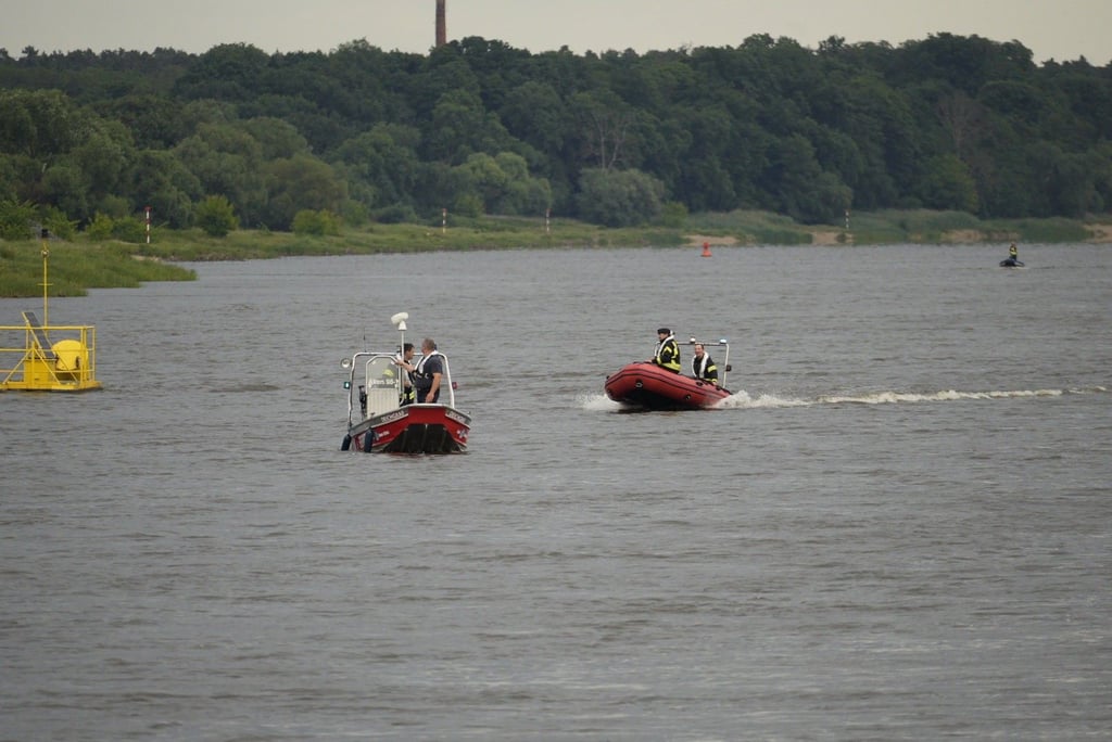 Mit Booten wird am Donnerstagabend die Elbe bei Brambach abgesucht.
