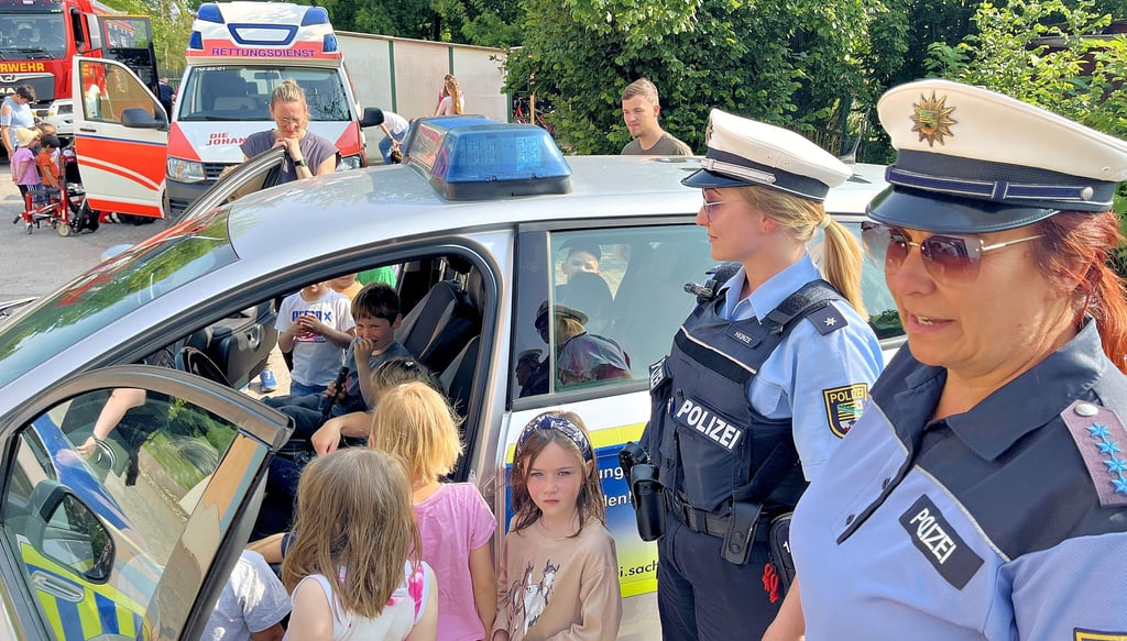 Blaulichttag in Tangerhütte: Die Regionalbereichsbeamten Kathrin Spindler (von rechts) und Rebecca Heinze lassen die Kinder mal ins Polizeiauto schauen - und die Lautsprecherfunktion austesten.