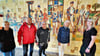 Restauratorin Claudia Müller (2.v.r) schaute sich jüngst mit Vertretern des Schmiedvereins und Kunstlehrerin Kathleen Fischer (rechts) das in die Jahre gekommene Mosaik an. Es soll demnächst restauriert werden. 