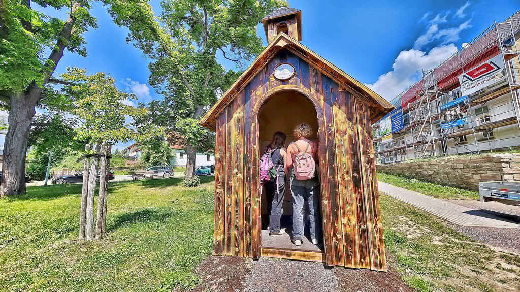 Zwei Studentinnen aus Halle schauen sich auf dem Kunstparcours in Allstedt die Kapelle der Sehnsucht an.