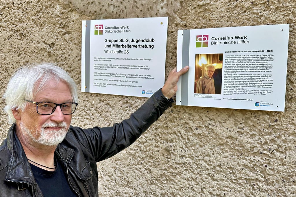 Stefan Böhme von der Geschäftsführung des Cornelius-Werkes in Burg zeigt auf die Gedenktafel für Volkmar Jenig.
