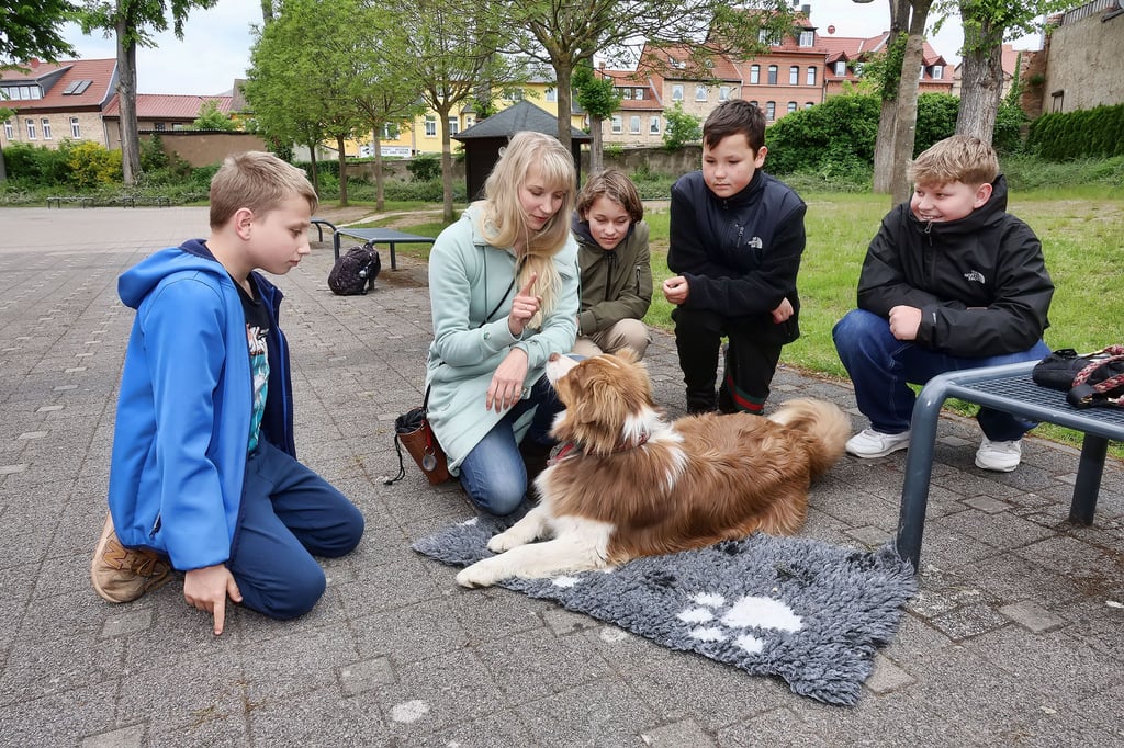 Christina Schneppe (2.v.li.) zeigt mit Cooper wie man Hunden eindeutige Befehle gibt.  Pascale (li.)  sowie  Andrea, Oscarund Franz  Franz lernen in der Schulhund-AG viel über den Umgang mit den Vierbeinern. 