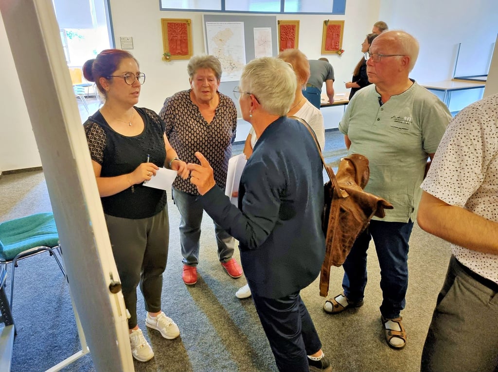 Sandy Jokiel (l.) von der Genehmigungsbehörde für den Linienverkehr spricht mit Bürgern aus Wülknitz.