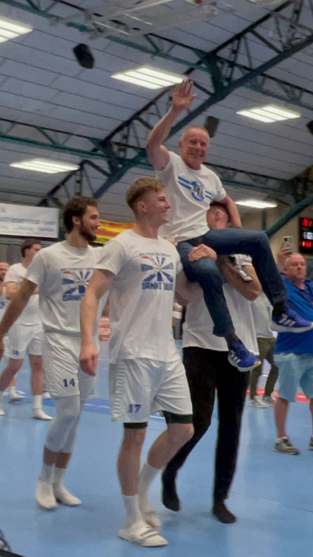 Trainer Uwe Jungandreas wird von den Spielern auf den Schultern durch die Halle getragen.