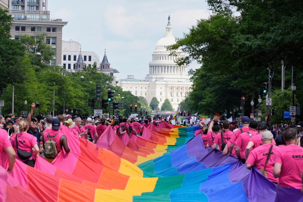 Mit riesigen Regenbogenfahnen demonstrieren Menschen mit Blick auf das US-Kapitol bei einer Pride-Parade in Washington für die Rechte der LGBTQI+-Gemeinschaft.