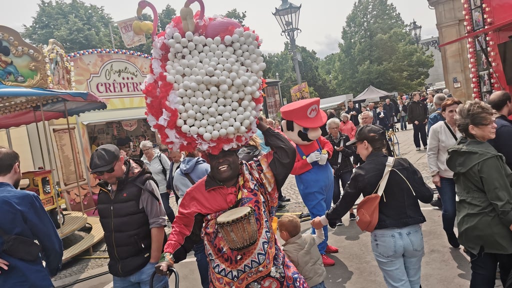 Ein singender afrikanischer Eiermann mit zig Eiern auf dem Kopf bringt die Besucher des Magdeburger Stadtfesten zum Schmunzeln.