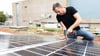 Olaf Lies, damals noch als Wirtschaftsminister, montiert ein Solarmodul auf ein Dach. (Archivbild)
