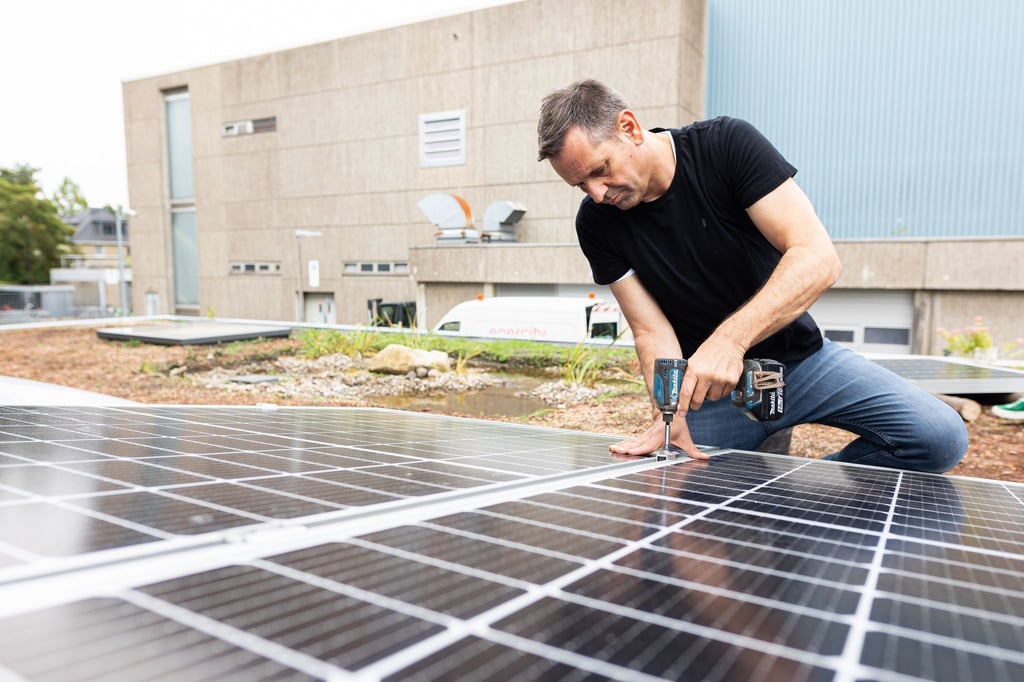 Olaf Lies, damals noch als Wirtschaftsminister, montiert ein Solarmodul auf ein Dach. (Archivbild)