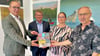 Das Grüger-Buch wird an die Kuratoriumsmitglieder Markus Bauer (von links) und Bert Knoblauch von Susanne Kalisch und Frank Pudel übergeben.