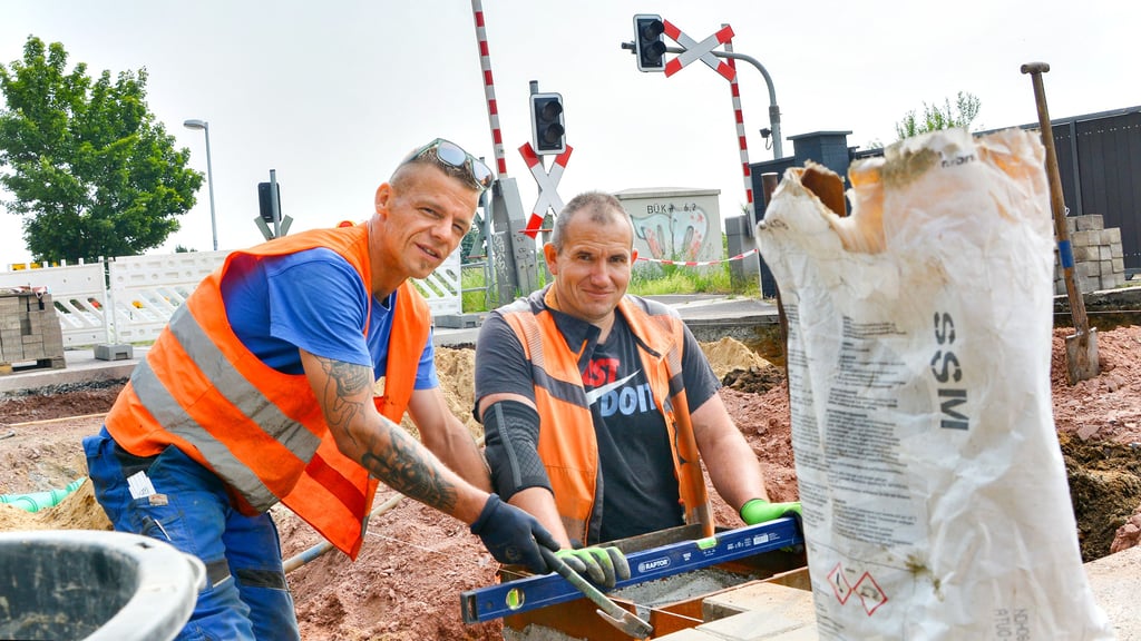 Simon Jentzsch (links) und Tobias Ruch gehören zum Tiefbau-Team, das am Bahnübergang in Meitzendorf in der Börde das jahrelang andauernde Problem behebt.