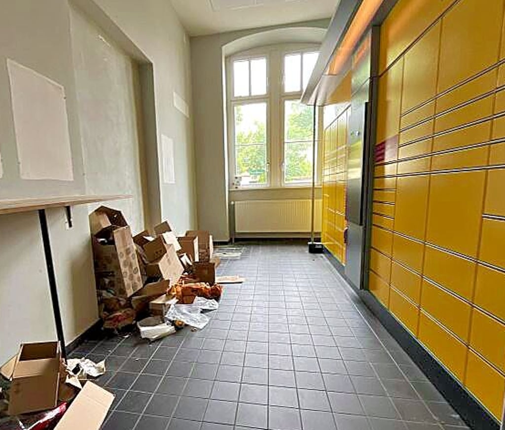Pappe und Verpackungsmaterial liegen vor den Schließfächern der Packstation.