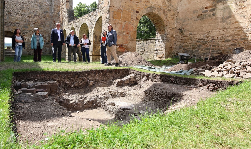 Teilnehmer einer Pressekonferenz des Landesamts für Denkmalpflege und Archäologie Sachsen-Anhalt stehen an der Grabungsstelle in der Ruine der Stiftskirche St. Marien in Walbeck.