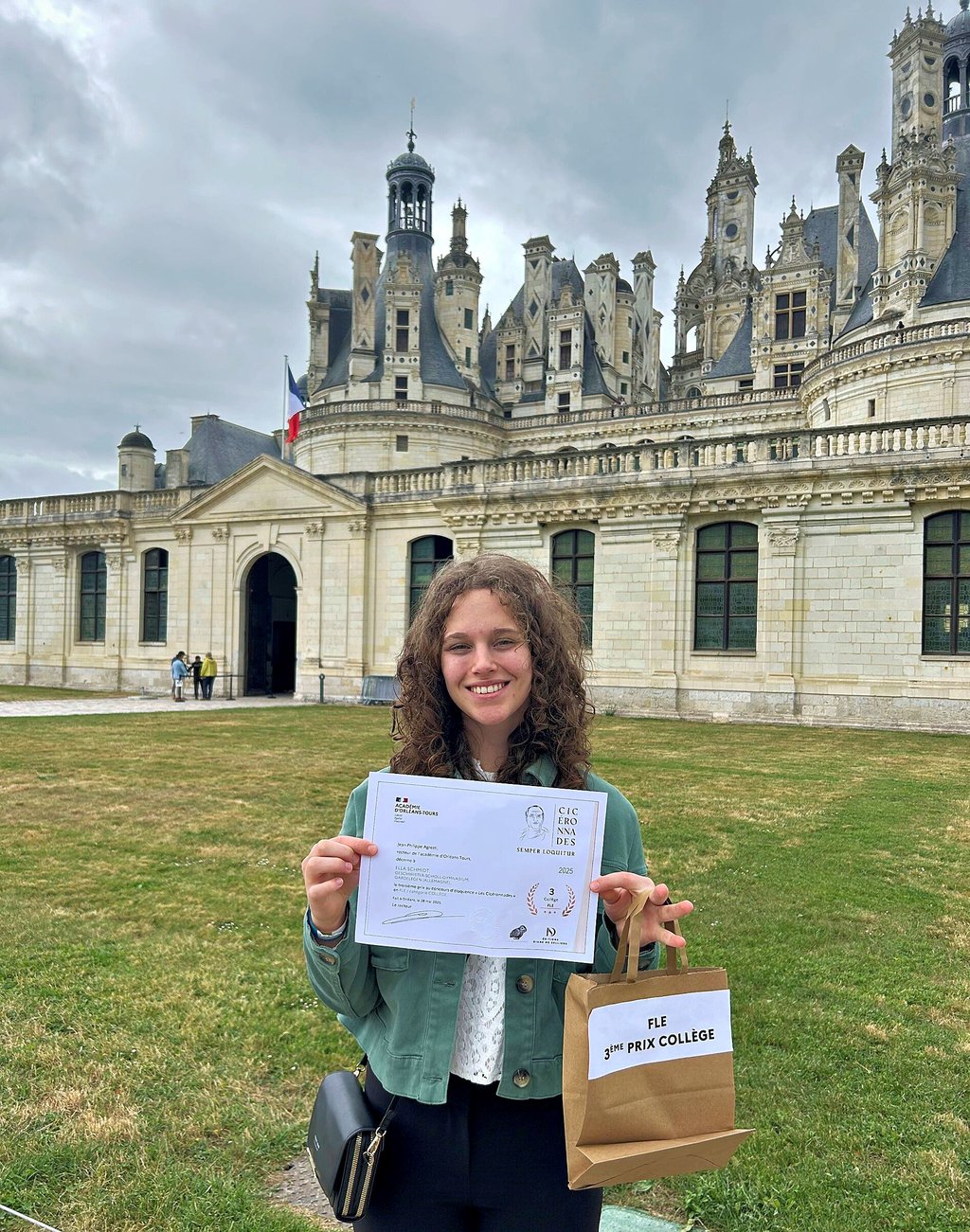 Schülerin Ella Schmidt vor dem Schloss Chambord mit ihrer Siegerurkunde.