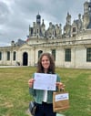 Schülerin Ella Schmidt vor dem Schloss Chambord mit ihrer Siegerurkunde. 