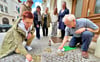 Claudia Schöne und Joachim Grossert polieren die neun Stolpersteine, die vor dem Haus Wilhelmstraße 1 verlegt sind, auf Hochglanz. Auch Christiane Heinevetter (stehend von links), Kerstin Schmidt, Judith Gebauer, Alexandra Stöhr und Anett Gottschalk engagieren sich für den Arbeitskreis „Jüdische Geschichte in Bernburg“.