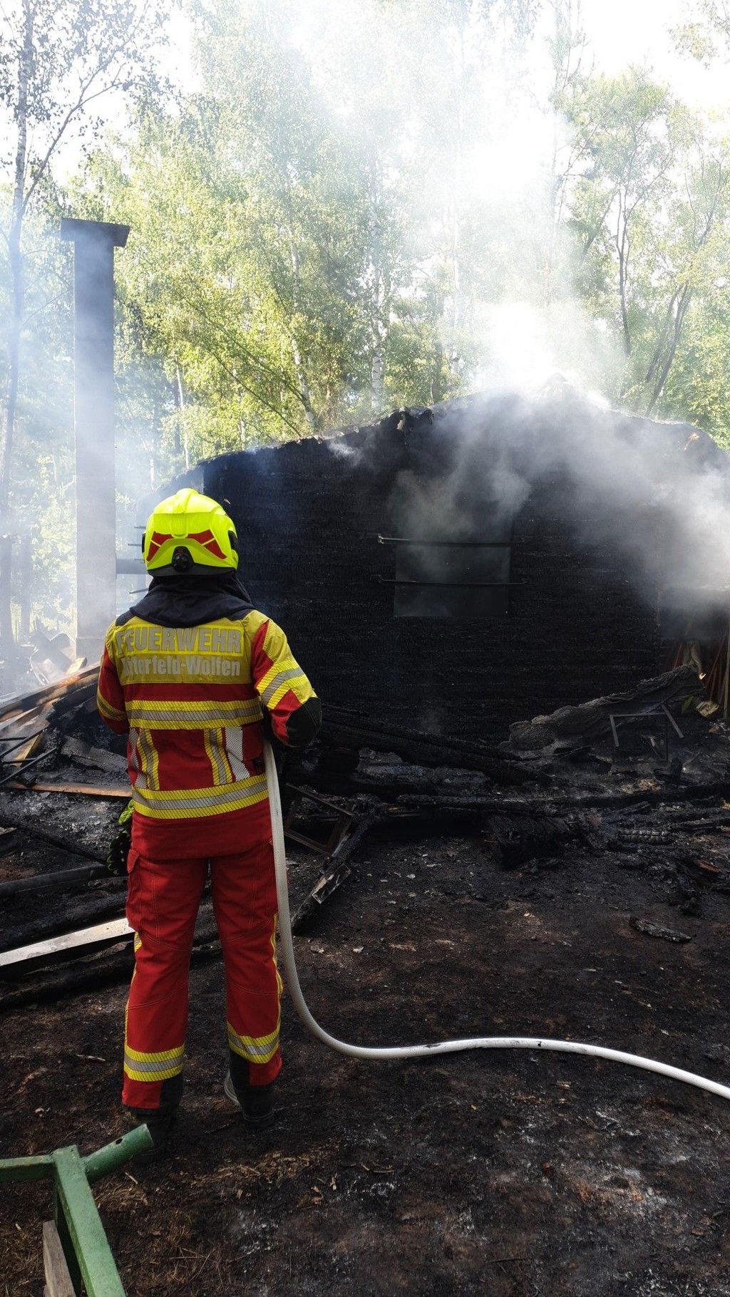 Eine Feuerwehrmann bei den Löscharbeiten an der Jagdhütte.