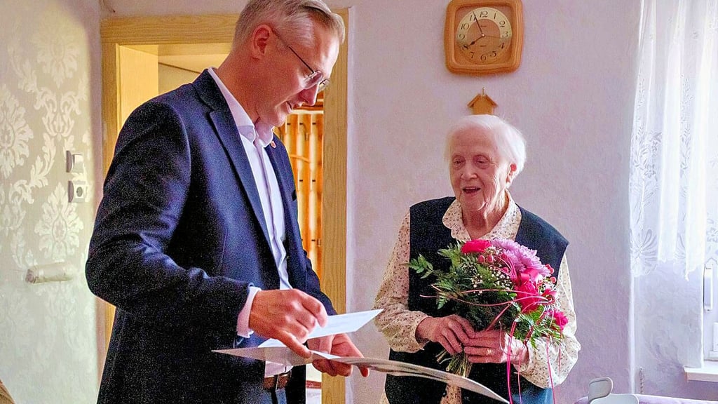Bürgermeister Seidig überreicht Blumen und Glückwünsche zum 100. Geburtstag an Helga Antonia Rüdiger.