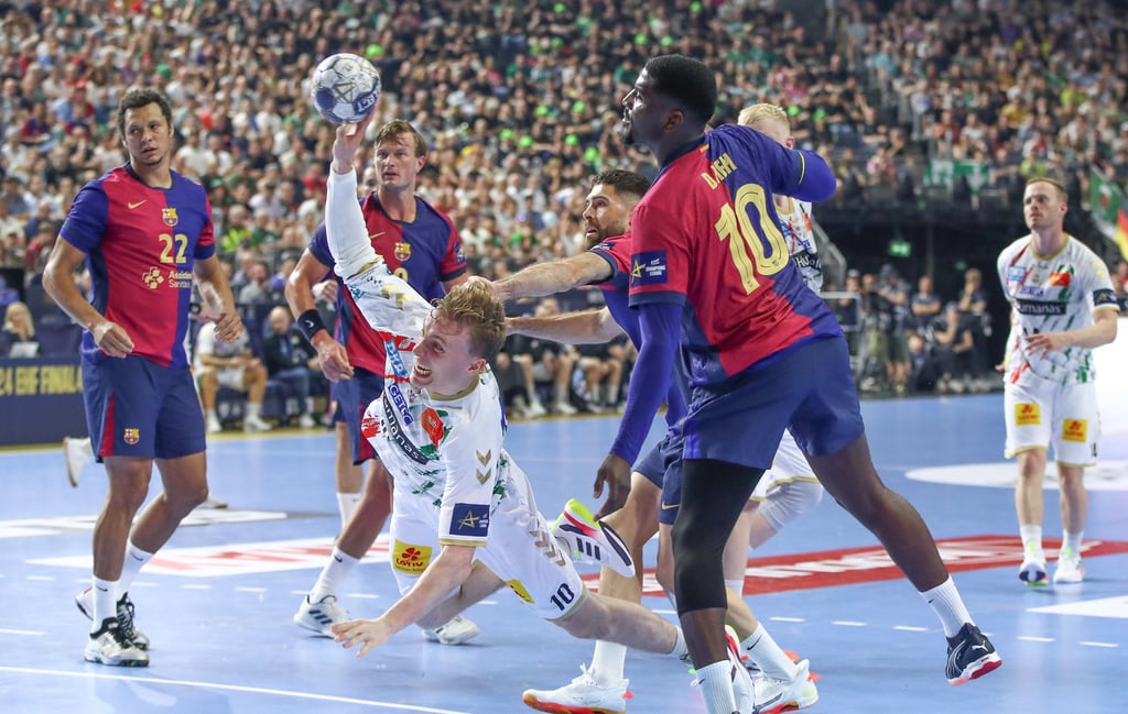 Gisli Kristjansson setzt sich hier gegen die Barca-Abwehr toll durch. Links verfolgt Thiagus Petrus Goncalves dos Santos den Wurf. Kurz vor der Pause sah der Brasilianer nach einem Griff ins Gesicht von Kristjansson die Rote Karte.