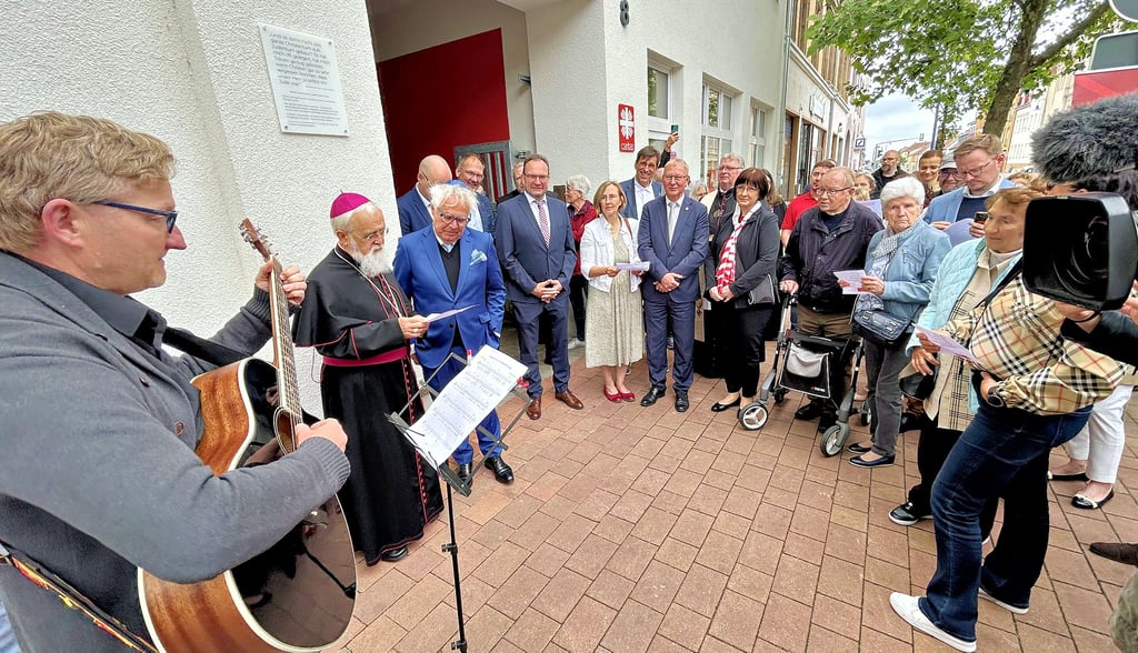 Viele Gäste begleiten die Enthüllung der Gedenktafel mit Bernd Sucher (3.v.l.) und Bischof Gerhard Feige vor dem neuen Caritas-Haus.